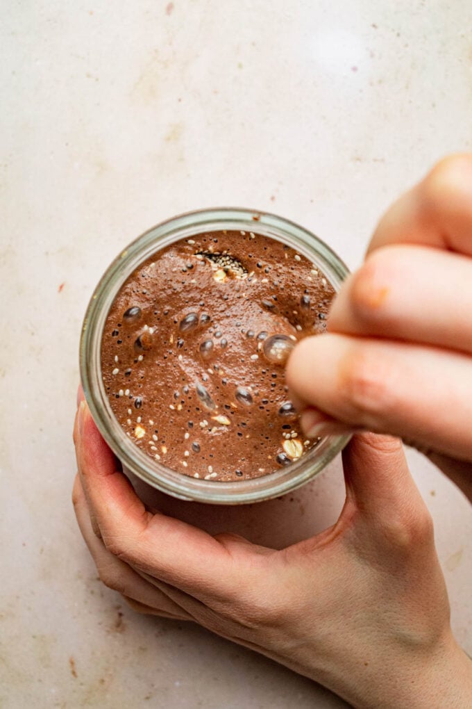 hand stirring overnight oats in jar