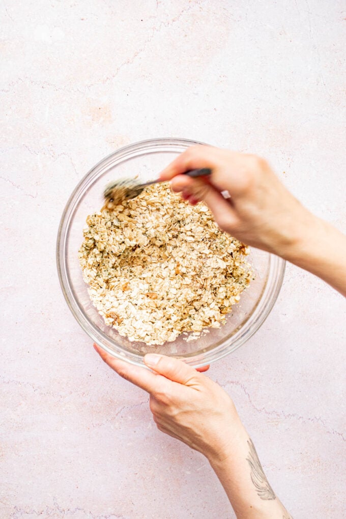 hand stirring oats in bowl