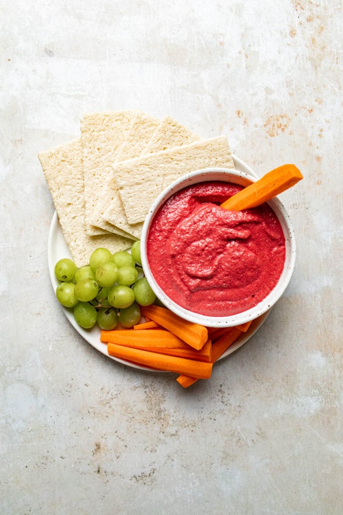 beet dip in bowl with carrots