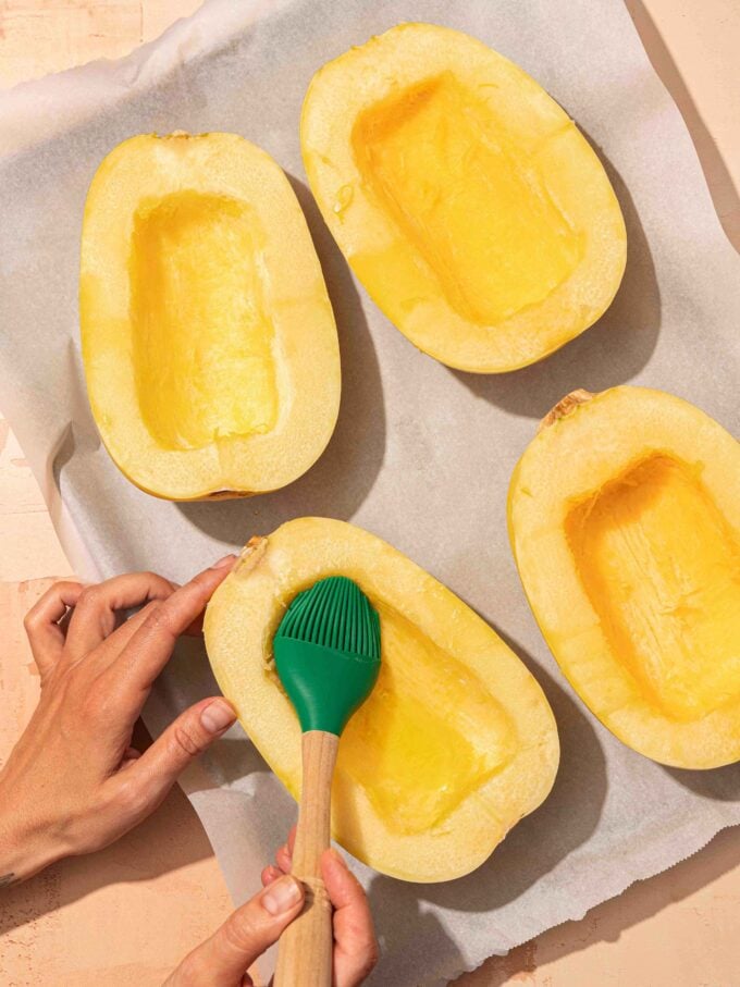 hand brushing spaghetti squash