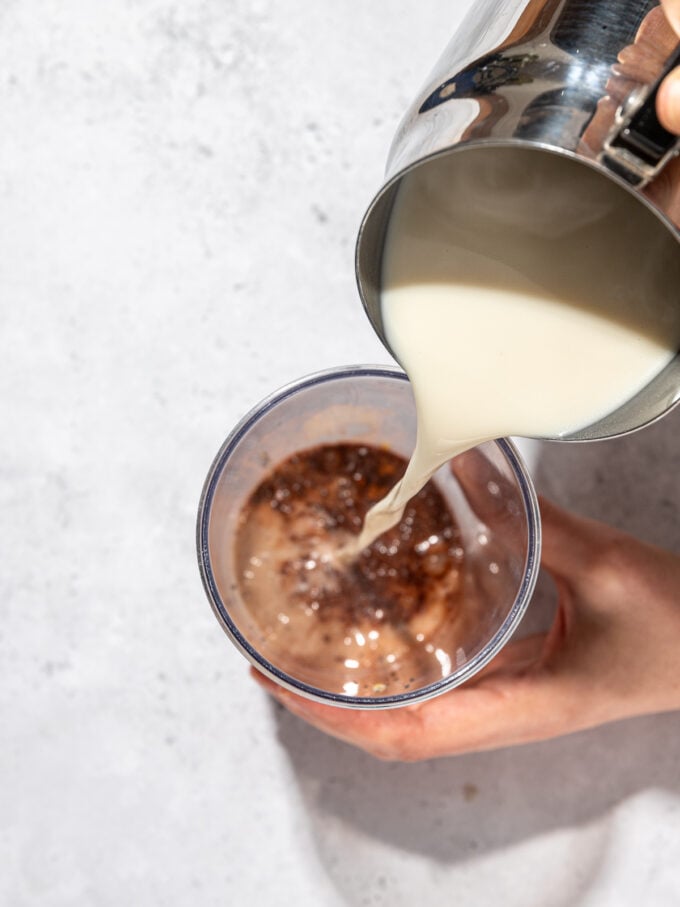 pouring oat milk into cup