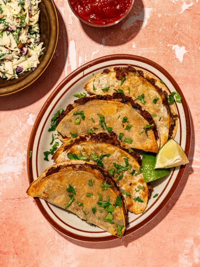 black bean tacos on plate with lime wedges