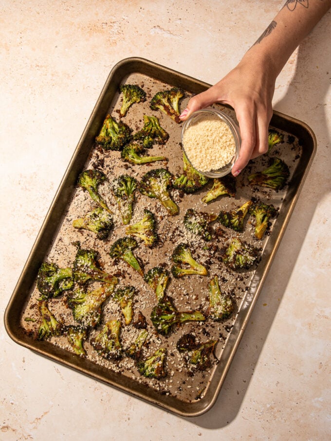 hand sprinkling panko over broccoli