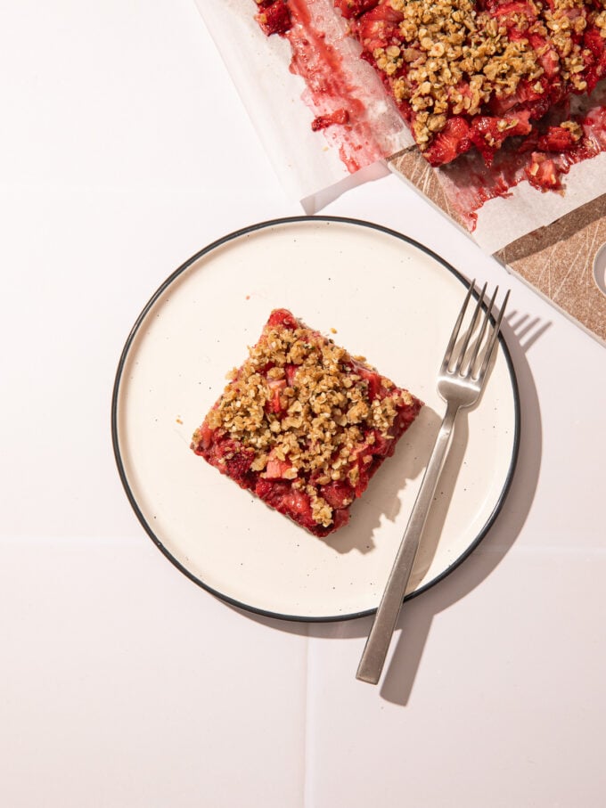 strawberry oatmeal bar on white plate with fork