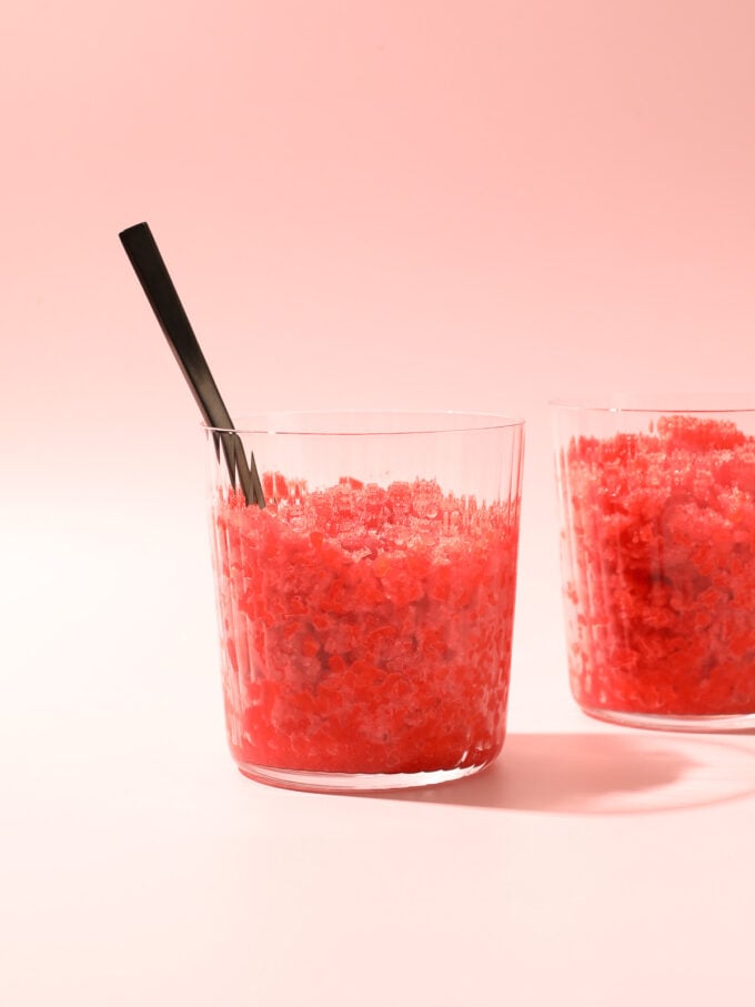 strawberry granita in glass with black spoon