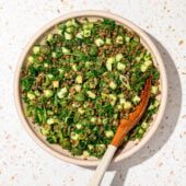 lentil salad with herbs in bowl with wooden spoon