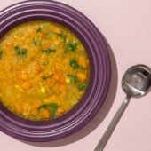 lentil soup in purple bowl with spoon