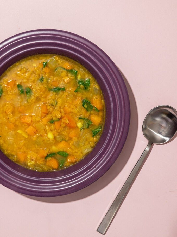 lentil soup in purple bowl with spoon