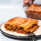 vegan lasagna on white plate with fork