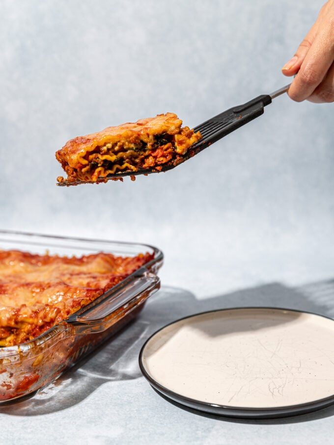 hand serving lasagna