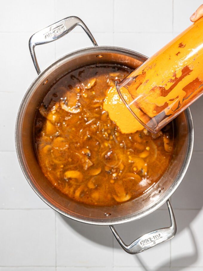 pouring liquid into mushroom lentil stew