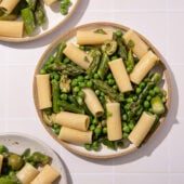 white plates with pasta, peas and asparagus