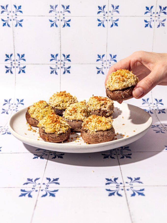 hand holding artichoke and tofu stuffed mushroom