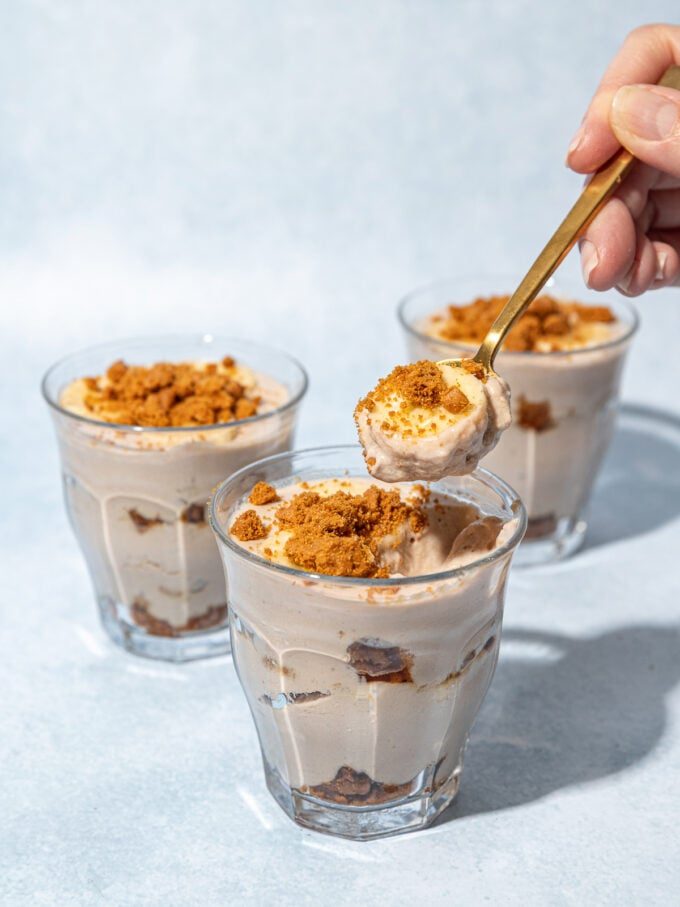 hand scooping banana biscoff pudding out of dessert glass