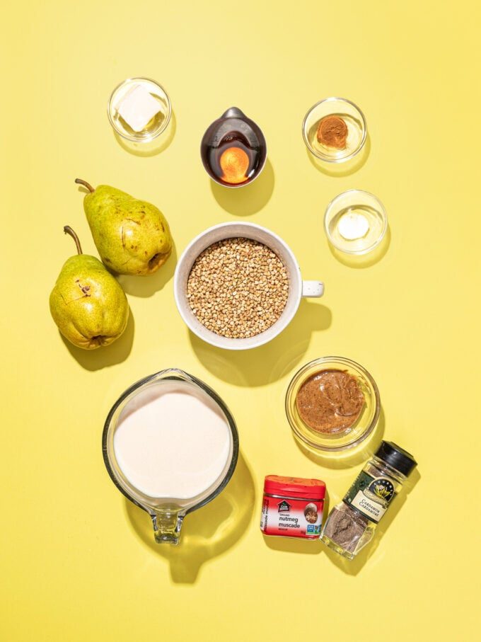 bowls of soy milk, buckwheat groats, almond butter, maple syrup, spices with pears