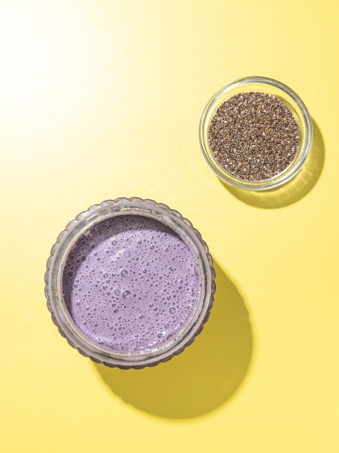 blended lemon blueberry milk in a jar with a dish of chia seeds beside it
