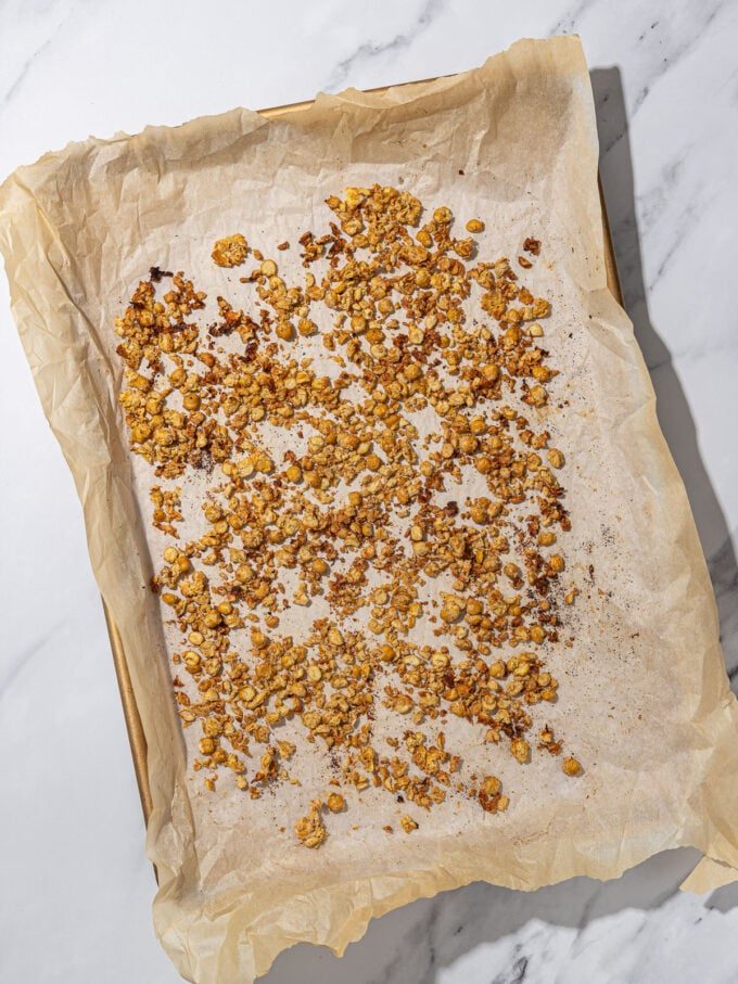 sheet pan, covered in parchment paper, with roasted chickpea crumbles on top